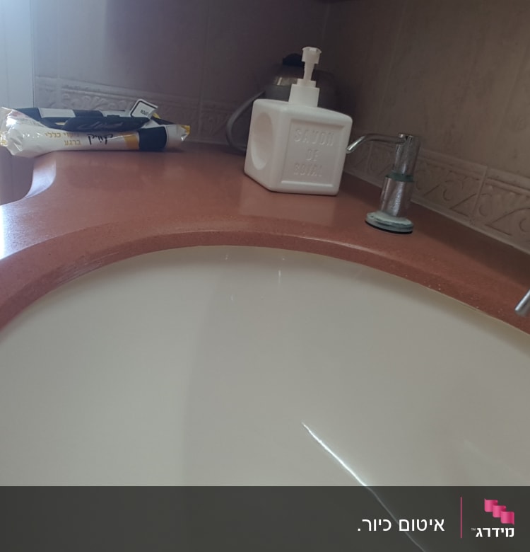 כיור עם ברז וסבון נוזלי על השיש